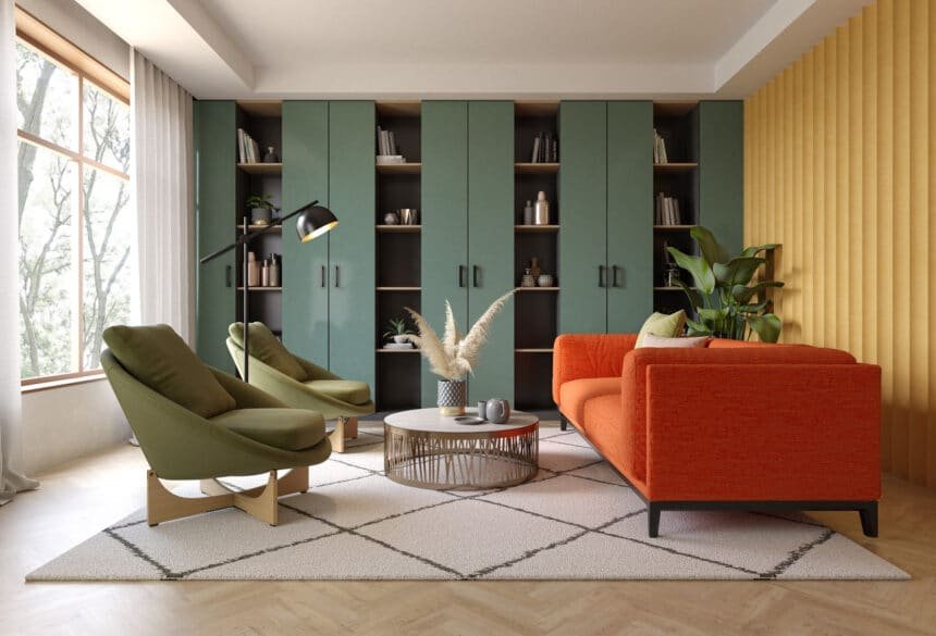 Salon moderne avec un canapé rouge, deux chaises vertes, une table basse ronde, des étagères encastrées avec des armoires, un lampadaire, et une grande fenêtre - mettant en valeur l'expertise d'un contractant général rénovation pour les espaces de style.