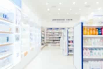 L'intérieur d'une pharmacie bien éclairée avec des étagères remplies de divers produits de santé et de beauté.
