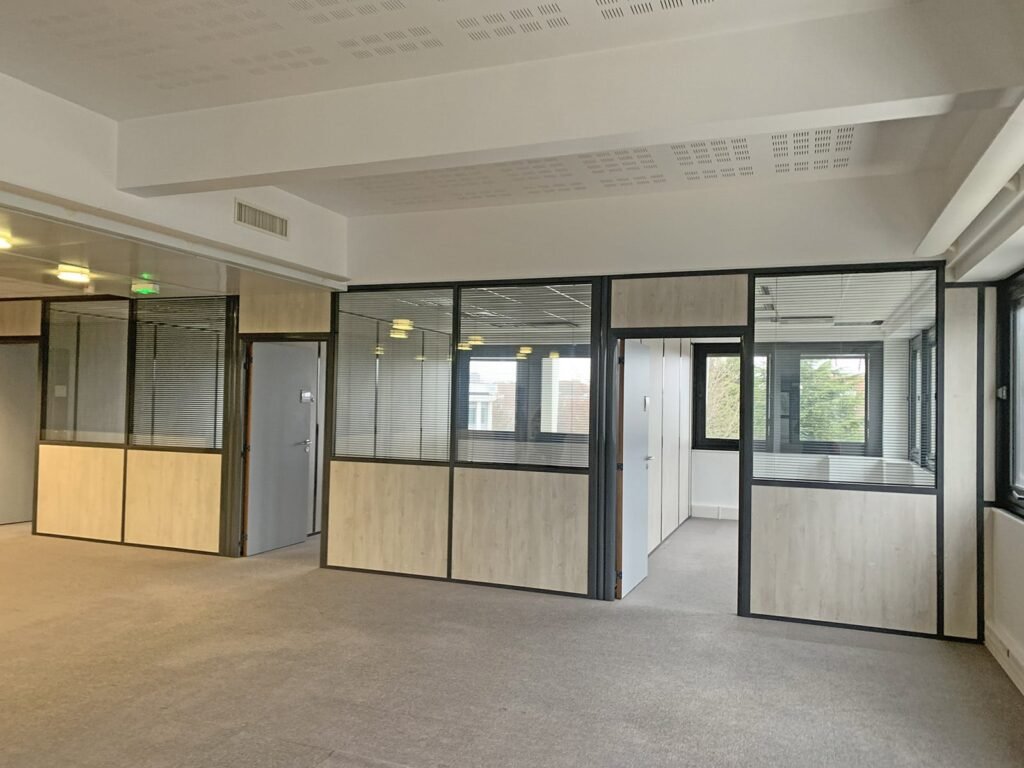 Un bureau vide avec des cloisons en verre et des murs en bois.