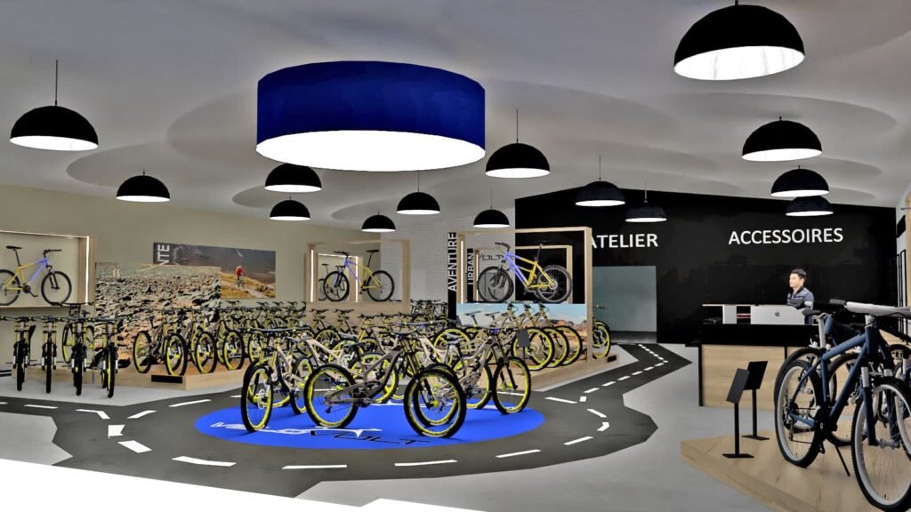 Intérieur d'un magasin de vélos moderne avec plusieurs vélos en exposition, un comptoir de service à la clientèle, des lampes suspendues et des zones réservées aux accessoires et aux ateliers.