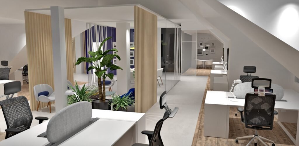 Espace de bureau ouvert moderne avec plusieurs bureaux, des chaises ergonomiques, des plantes d'intérieur et un coin salon cloisonné sous un plafond incliné.
