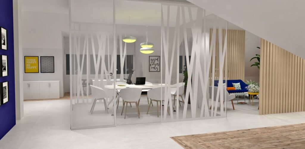 Salle de réunion de bureau moderne avec des murs en verre, des chaises blanches autour d'une table, des lampes suspendues au-dessus, et un coin salon avec des plantes et des coussins décoratifs à l'arrière-plan.