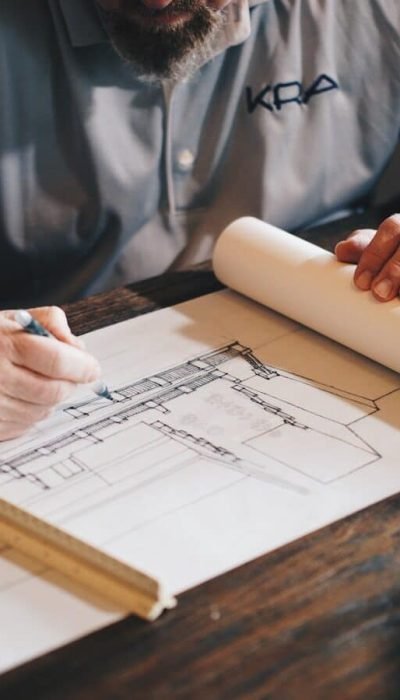 An architect working on a draft with a pencil and ruler